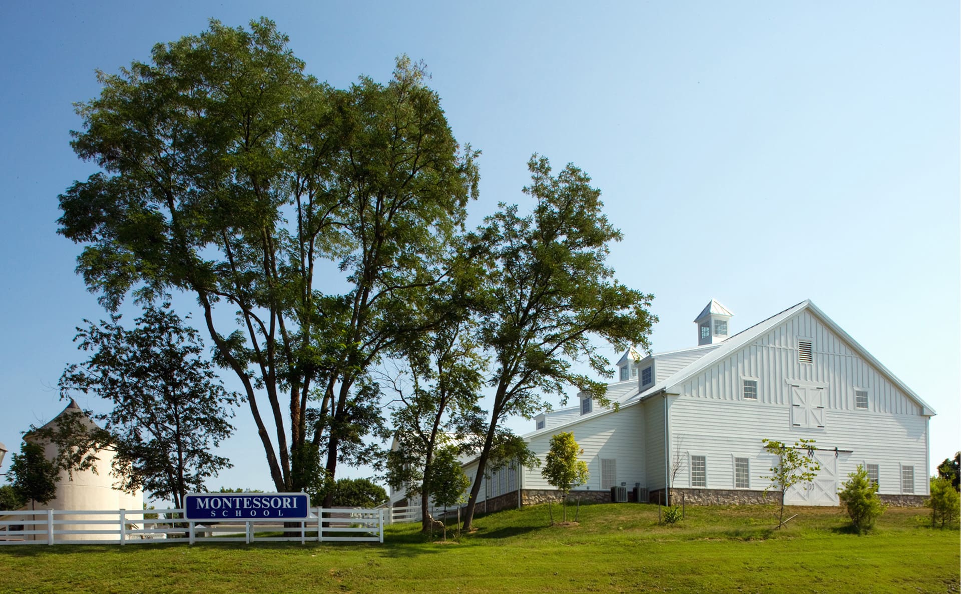 Outside of the barn style Montessori School, including the signage and surrounding area